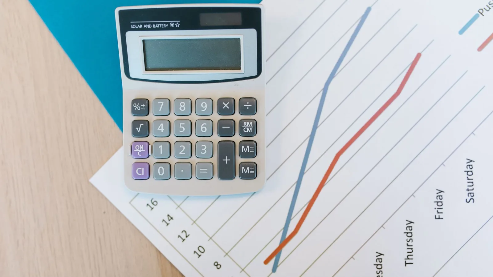 Ein Taschenrechner und Finanzunterlagen auf einem Schreibtisch